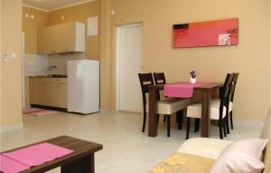 a kitchen and dining room with a table and a refrigerator at Pet Friendly Apartment In Porec With Wifi in Poreč