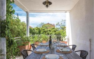 a wooden table with wine glasses on a balcony at 3 Bedroom Stunning Apartment In Makarska in Makarska