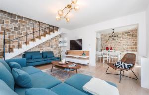 ein Wohnzimmer mit einem blauen Sofa und einer Ziegelwand in der Unterkunft Cozy Home In Milna With House Sea View in Milna