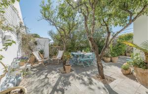 a patio with a table and chairs and trees at La Casa Di Marina in Marittima