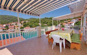 a patio with a table and chairs on a balcony at Nice Apartment In Brna With 4 Bedrooms And Wifi in Brna