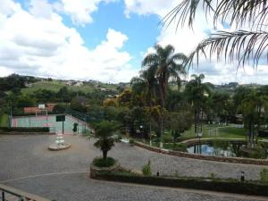 a park with palm trees and a pond at Piemonte Flat Serra Negra in Serra Negra