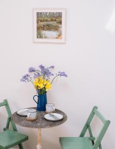 a table with a vase of flowers and two chairs at Field View Lodge in Niton