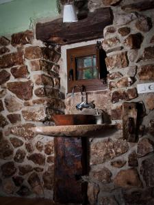 a stone bathroom with a sink in a stone wall at Casa Rural La Ardina in Sotres