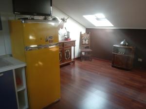 a kitchen with a yellow refrigerator and a tv on top at " Le Chic" in Pregnana Milanese