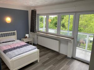 a bedroom with a bed and two windows at Schöne Lemgoer Unterkunft in Lemgo