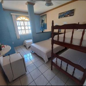 a bedroom with two bunk beds and a window at POUSADA SHALON in Guarapari