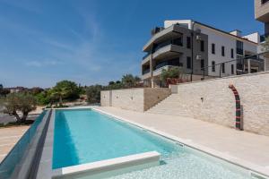 a swimming pool in front of a building at Apartment MaLu in Banjole
