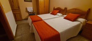 A bed or beds in a room at Hostal de la Playa