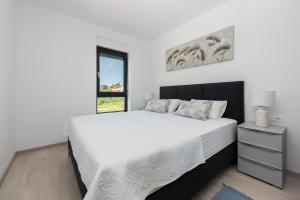 a bedroom with a white bed and a window at Apartment MaLu in Banjole +28 photos