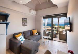 a living room with a couch and a view of the ocean at Kalipso & Nafsika Maisonettes Grey Diamond in Nikiana