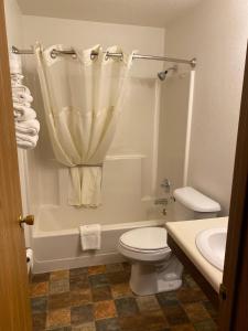 a bathroom with a toilet and a tub and a sink at Americas Best Value Inn Kadoka in Kadoka