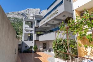 a building with a mountain in the background at Apartments Hudovernik in Baška Voda