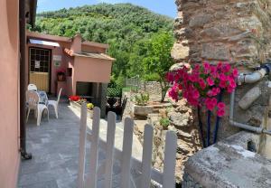 a white fence in front of a house with flowers at La camera del mulino in Levanto