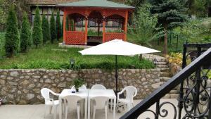 a table and chairs with an umbrella and a gazebo at Apartments Town Center in Sarajevo