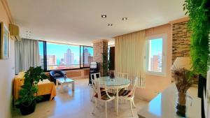 ein Wohnzimmer mit einem Tisch und Stadtblick in der Unterkunft Precioso apartamento con vistas al mar in Benidorm