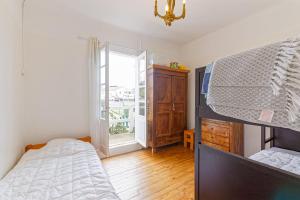 een slaapkamer met een stapelbed en een raam bij Toki Eder Anglet - Terrasse - Jardin - Océan - 4 chambres in Anglet