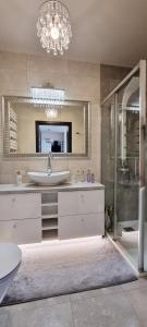 La salle de bains est pourvue d'un lavabo, d'une douche et d'un miroir. dans l'établissement Apartament Perła Juraty, à Jurata