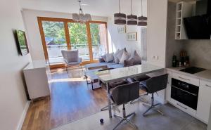 a kitchen and living room with a couch and a table at Apartament Perła Juraty in Jurata