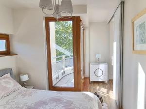 - une chambre avec un lit et une grande fenêtre dans l'établissement Apartament Perła Juraty, à Jurata