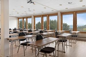 a classroom with tables and chairs and windows at Stav Hotel in Malvik