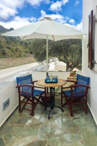 a table and chairs with an umbrella on a balcony at Pigi Rooms in Apollonia