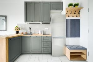 a kitchen with green cabinets and a refrigerator at Targowa 10 London Studio in Warsaw