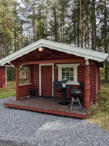 a small cabin with a porch and a table at Neset Skydsstasjon in Flesberg