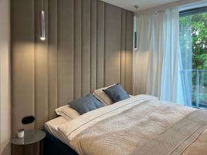 a bedroom with a large bed and a window at Apollo Luxury Apartment Dolny Sopot in Sopot
