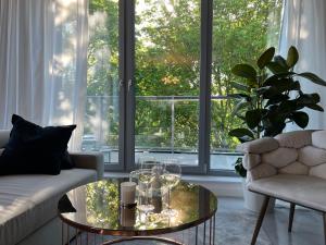 a living room with a glass coffee table in front of a window at Apollo Luxury Apartment Dolny Sopot in Sopot