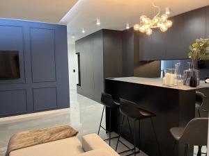 a kitchen with black cabinets and a island with stools at Apollo Luxury Apartment Dolny Sopot in Sopot