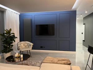 ソポトにあるApollo Luxury Apartment Dolny Sopotの青い壁のリビングルーム(テレビ付)