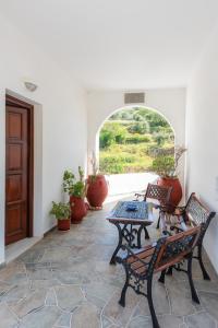 a patio with benches and a table and a window at Pigi Rooms in Apollonia