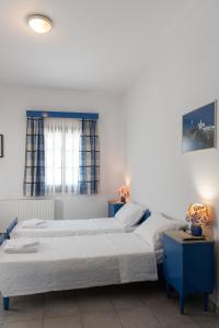 a bedroom with two beds and two tables at Pigi Rooms in Apollonia