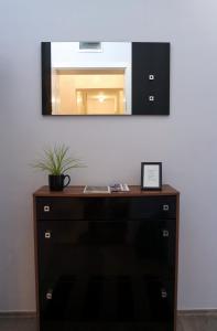 a wooden dresser with a mirror on a wall at Nidius Apartment in Debrecen