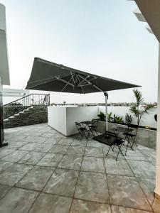 a patio with a table and chairs and an umbrella at KAPINGA'S HOUSE in Saly Portudal