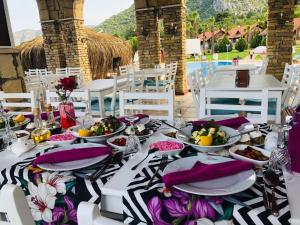 uma mesa com pratos e tigelas de comida em Club Sun Village Hotel em Adrasan