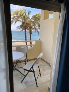 a view of the beach from a room with a table and chairs at Apartamento Las Mimosas Beach 2 in La Cala de Mijas