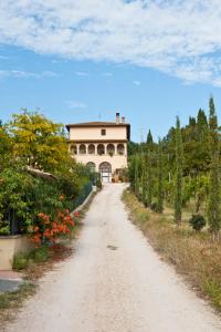 a dirt road in front of a building with trees at Casa Castellina in Foligno