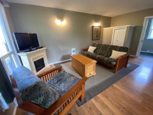 ein Wohnzimmer mit einem Sofa und einem TV in der Unterkunft Cedar Park Resort in Port McNeill