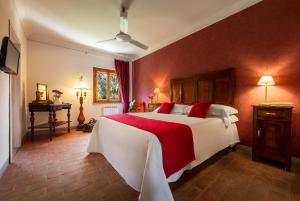 a bedroom with a large white bed with red accents at Tenuta Risalpiano in Pelago
