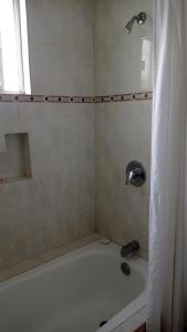 W łazience znajduje się wanna z prysznicem. w obiekcie Confort Ejecutivo Suites Lindavista w mieście Monterrey