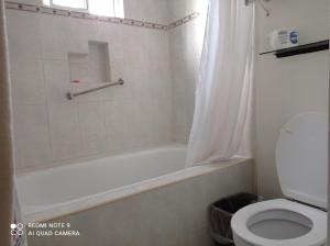 y baño con bañera blanca y aseo. en Confort Ejecutivo Suites Lindavista, en Monterrey