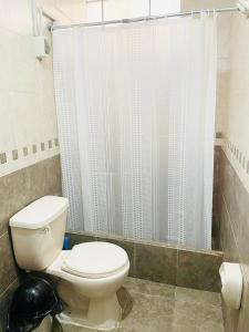 y baño con aseo y ducha. en Apartamento en el Centro de Trujillo - Primer Piso en Trujillo