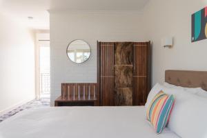a bedroom with a white bed and a mirror at Parador Inn in Adelaide