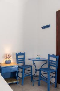 two blue chairs and a table and two tables and chairs at Pigi Rooms in Apollonia