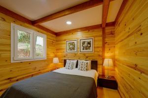 a bedroom with a bed in a room with wooden walls at Arrabia Bunga Douro in Raiva +25 photos