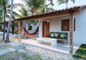 a porch with a couch and hammock in a resort at Pousada NAK - Nativa Arpoador Kite in Tutóia