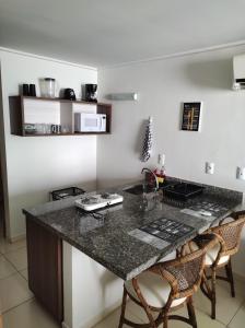 a kitchen with a granite counter top and chairs at Bluesunset in João Pessoa