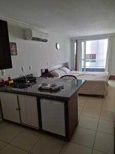 uma cozinha com um lavatório e uma cama num quarto em Bluesunset em João Pessoa